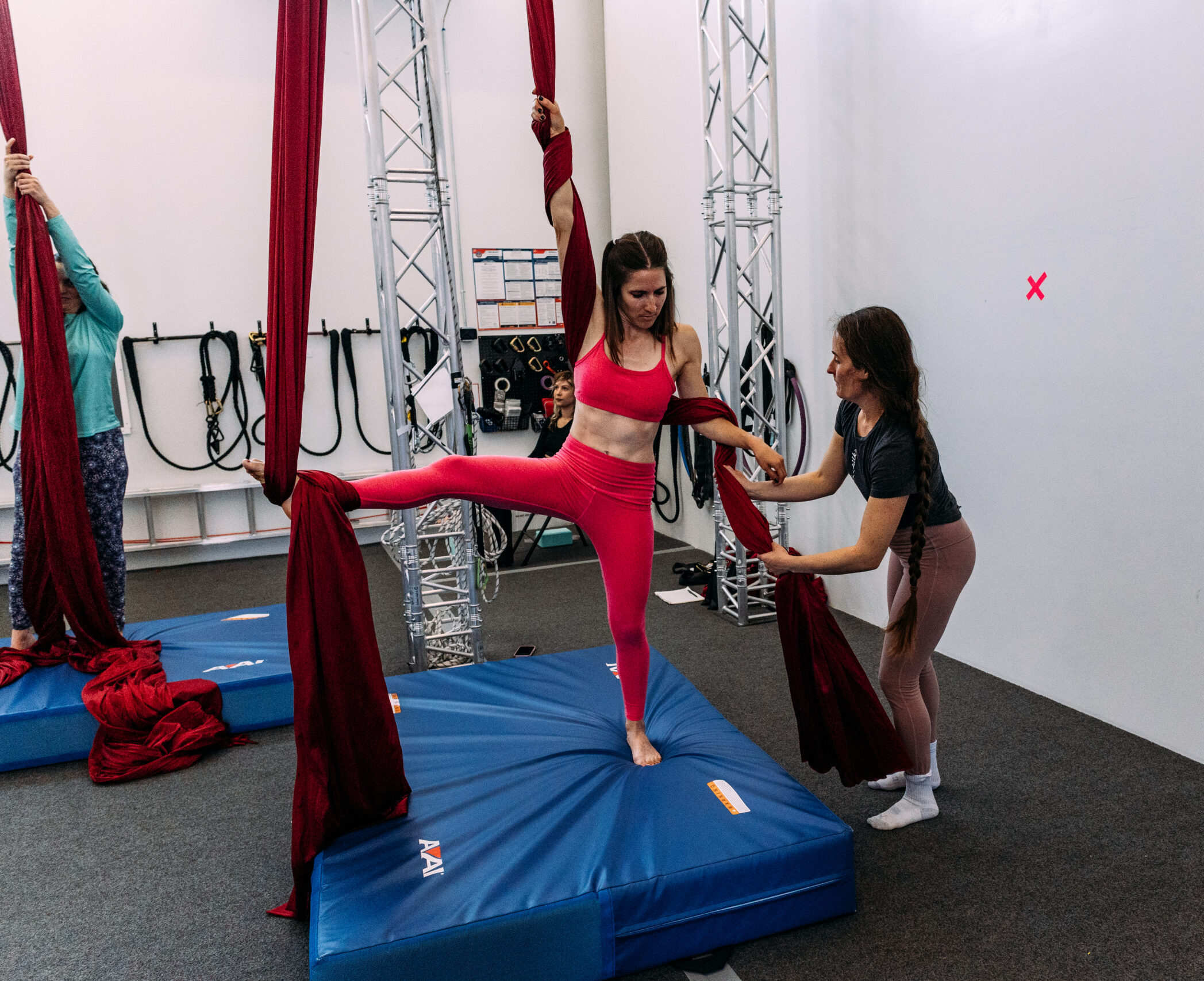 a coach helping an aerial dance adult student at teacher training