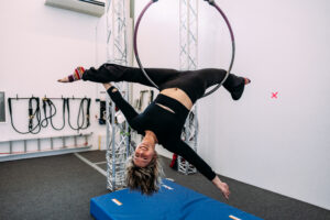 A adult on an aerial lyra hoop at aerial cirque over denver adult aerial dance classes