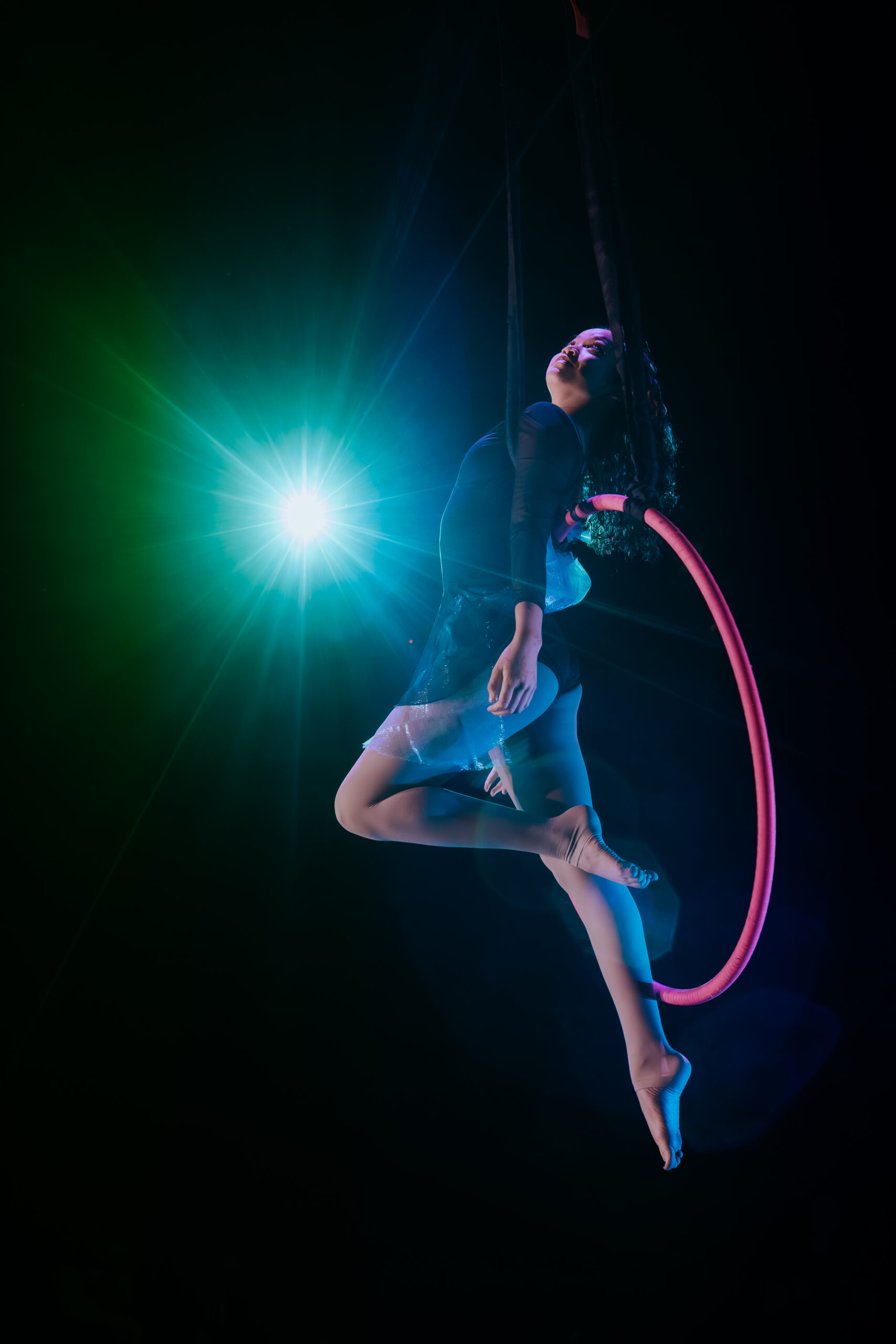 A youth aerial dancer performing at cleo parker robinson dance studio. She is on a lyra in a layback pose.