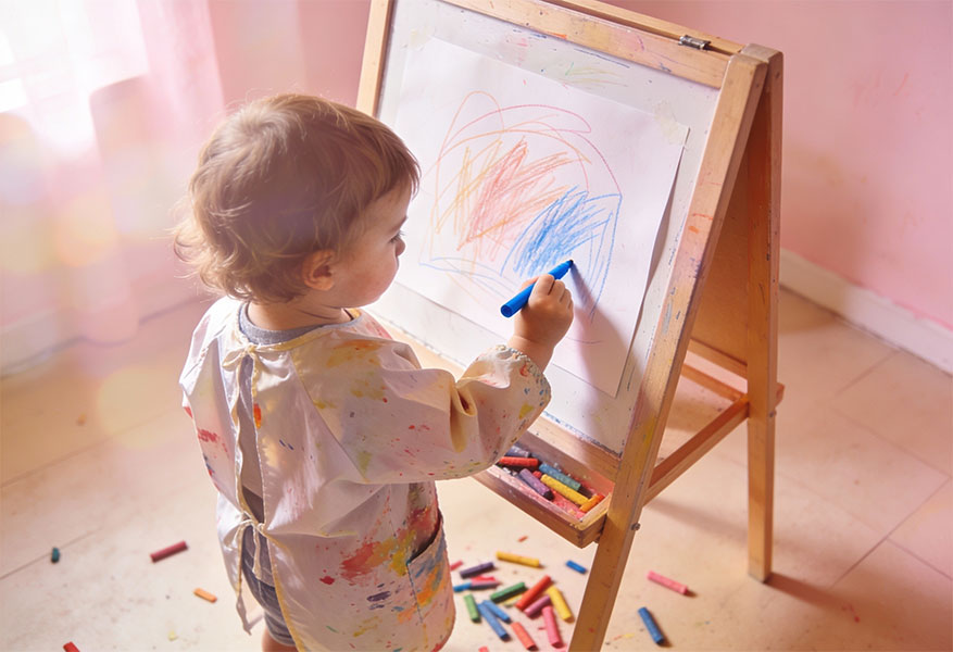 ACOD_a-toddler-stands-at-an-easel-coloring-a-picture--AerialCirqueOverDenver