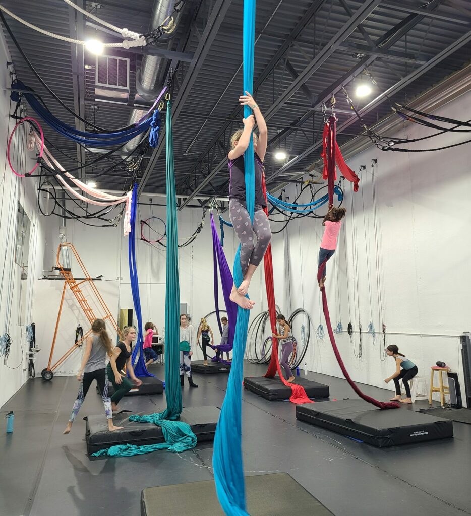 Summer aerial dance camp pre-teen dancer climbing aerial silks at Aerial Cirque Over Denver