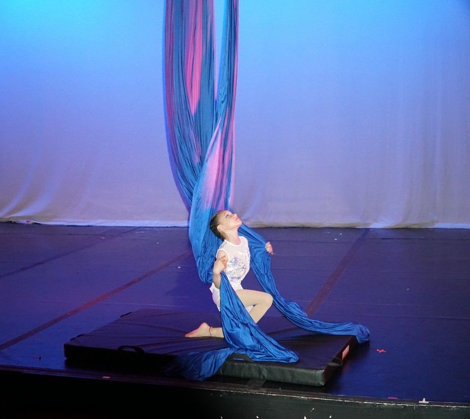 youth aerial silks dancer on a pose on the ground. Performing in a student showcase at Cleo parker robinson theatre.