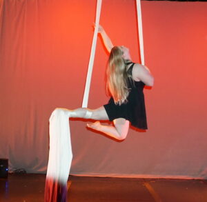 adult aerial student performing silks in student showcase denver