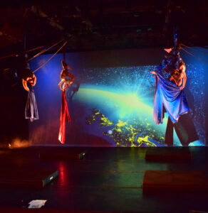 Four members of the aerial cirque over denver youth performance company are doing a group silks act at Cleo parker robinson dance theatre.