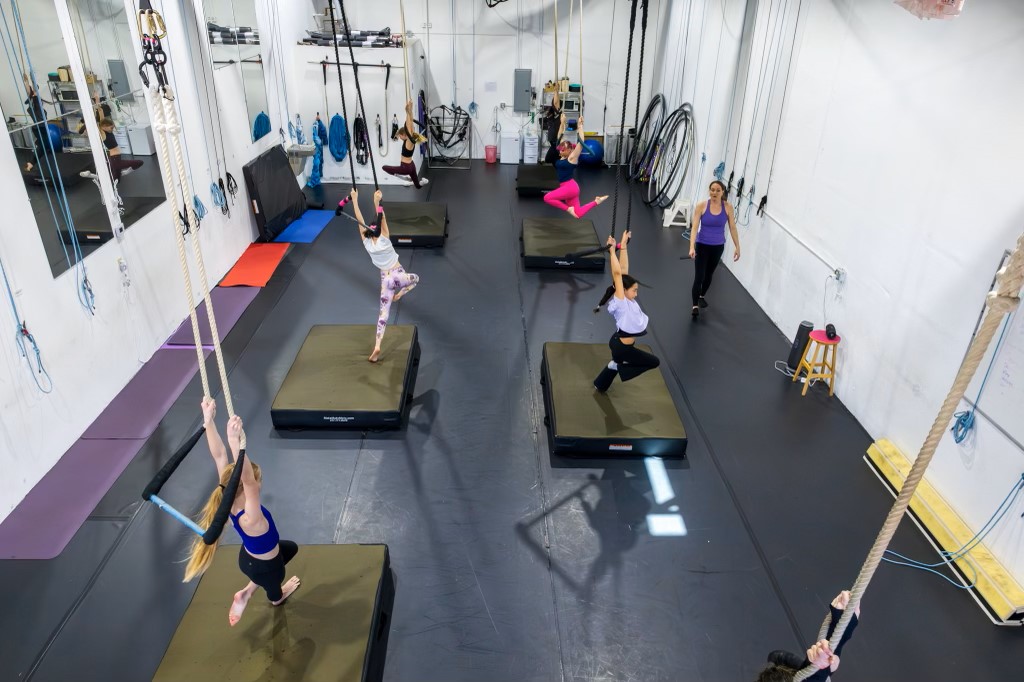 trapeze classes for preteens at aerial cirque over denver. Photo showing an aerial view of students on trapezes.