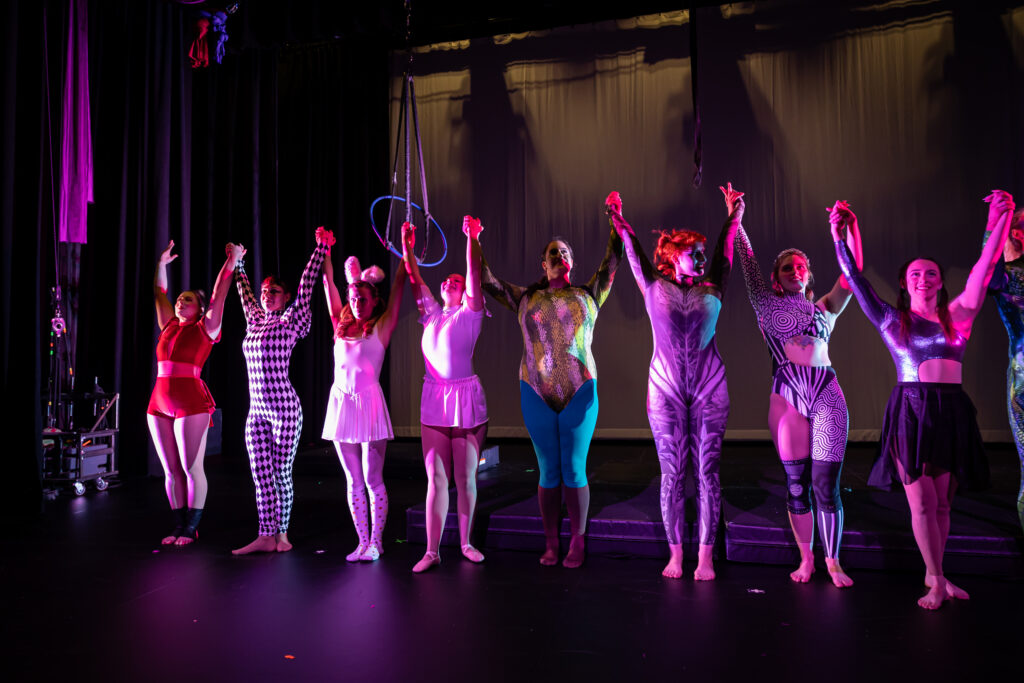 the adult performance company performers in a line, bowing towards the audience