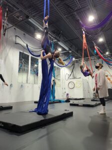 teen student upside down on aerial silks at circus school denver